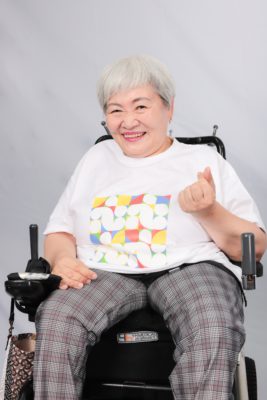 장애인지역공동체 티셔츠를 입고 손가락 하트를 보내는 활동가