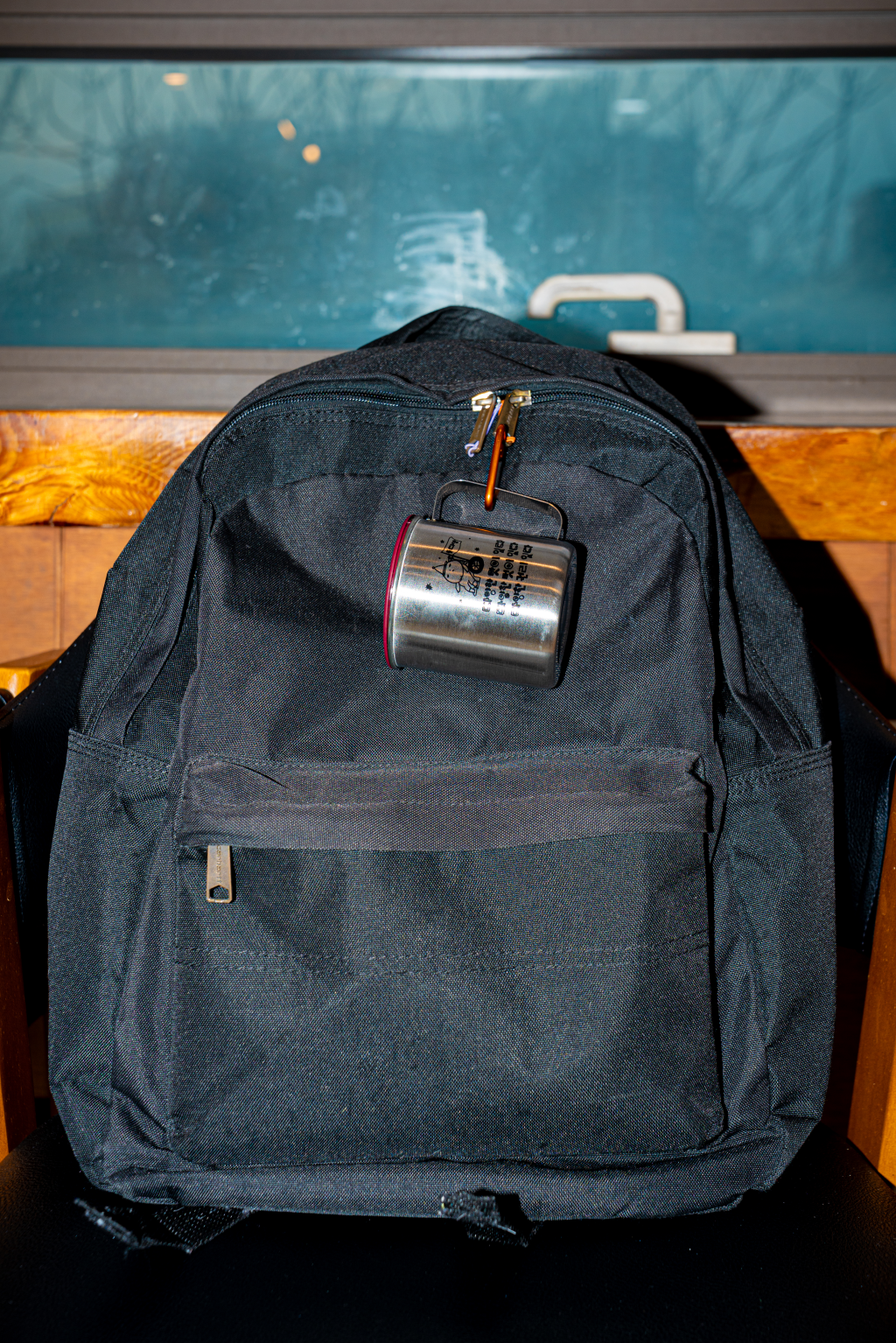 검은 가방에 매달린 들다방 스테인리스 키링 컵 사진. 검은 가방의 끈 손잡이에 들다방 컵이 키링으로 매달려 있다.