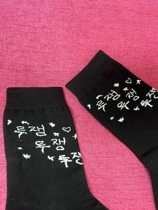 붉은색 배경아래 검정 투쟁투쟁투쟁이라고 손글씨로 적힌 양말 클로즈업